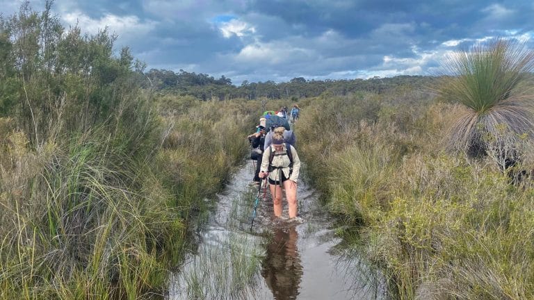 Teens hiking through flooded bibbulmun track