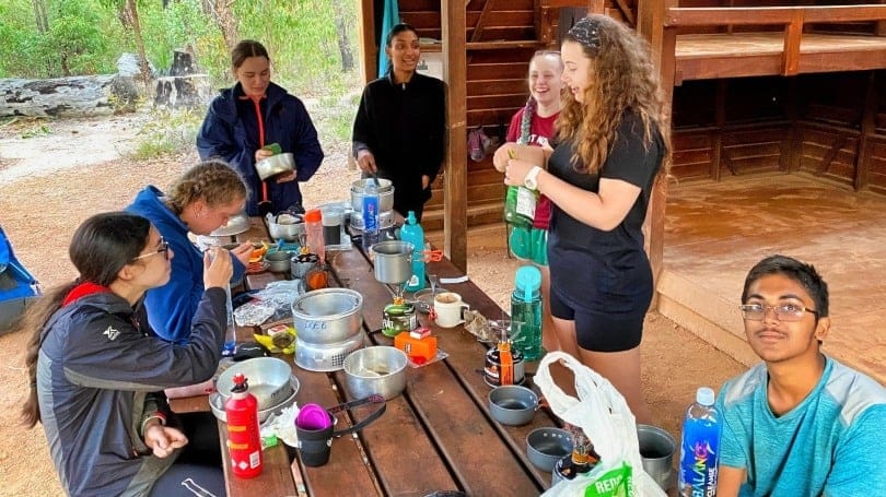 teens preparing dinner during hike