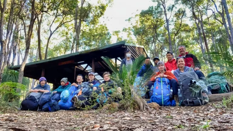 Group of teens in front of white horse campsite