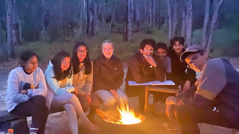 Group of teens around a campfire on the bibbulman track