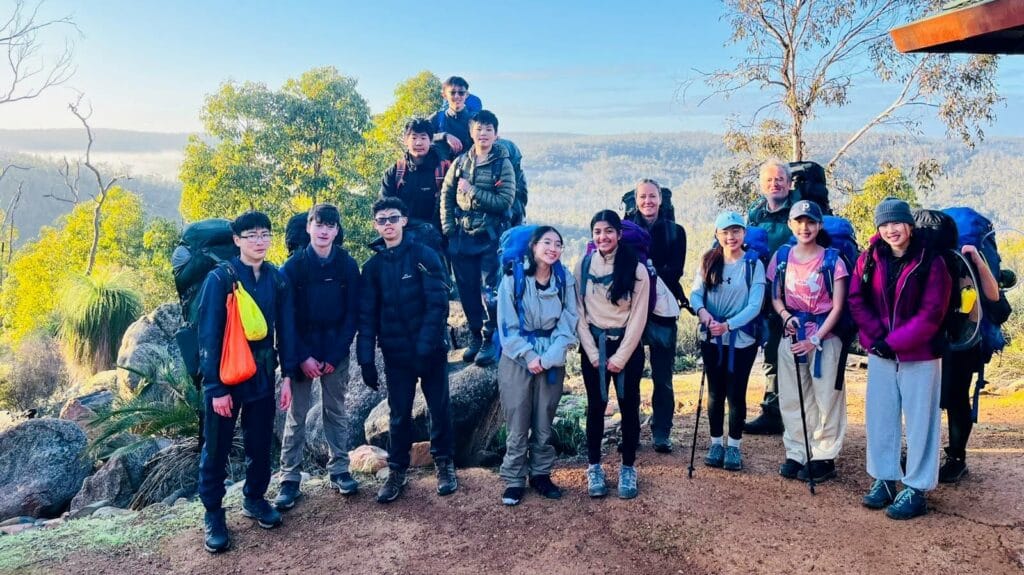 Group photo of teens on the Bibbulmun Track with the Helena Valley in the background