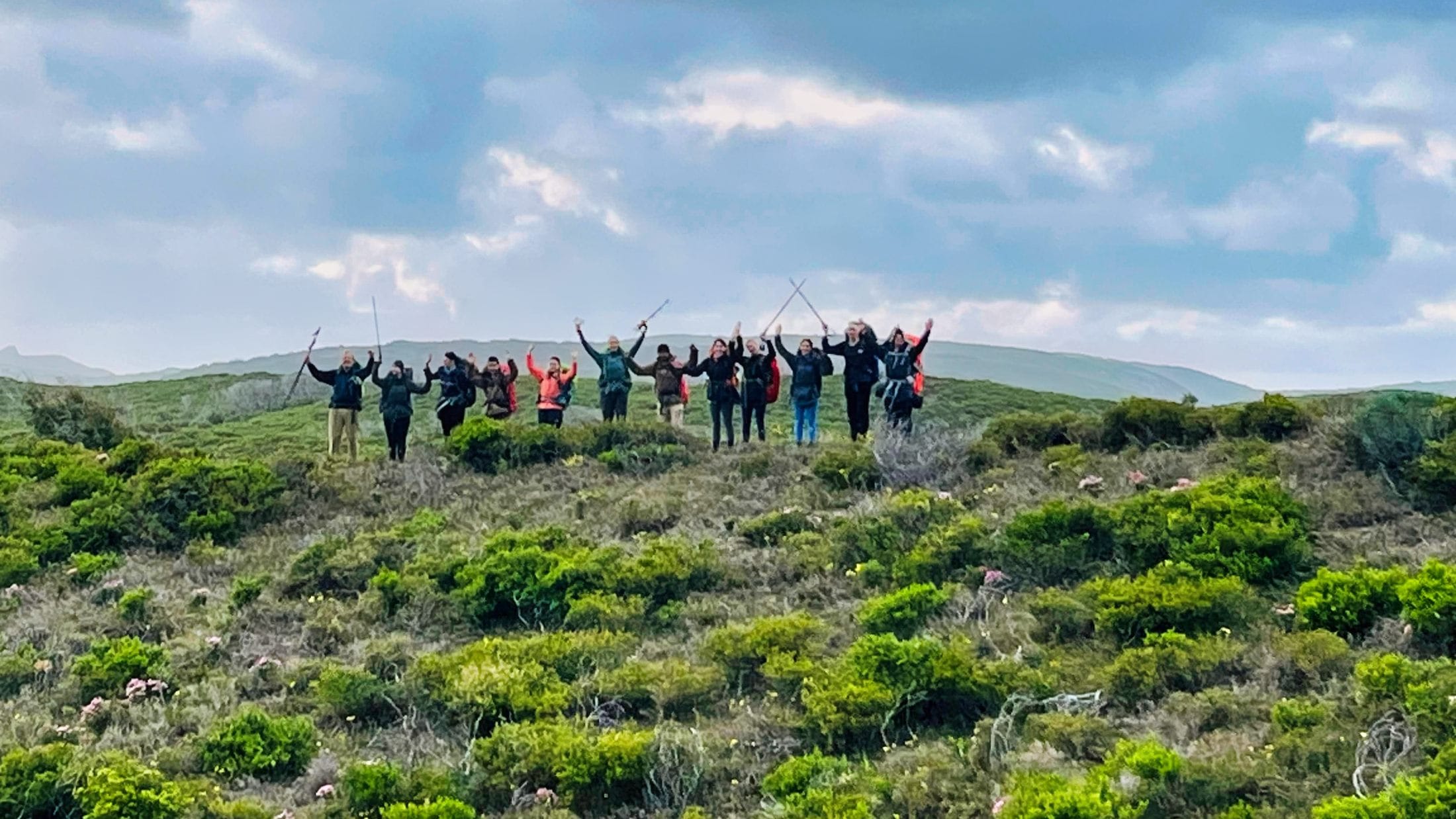 Teens celebrating their hike with hands in the air