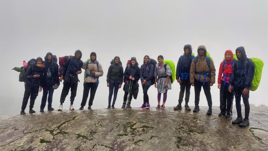 A group of teens hiking in the rain on top of mt cooke, western australia