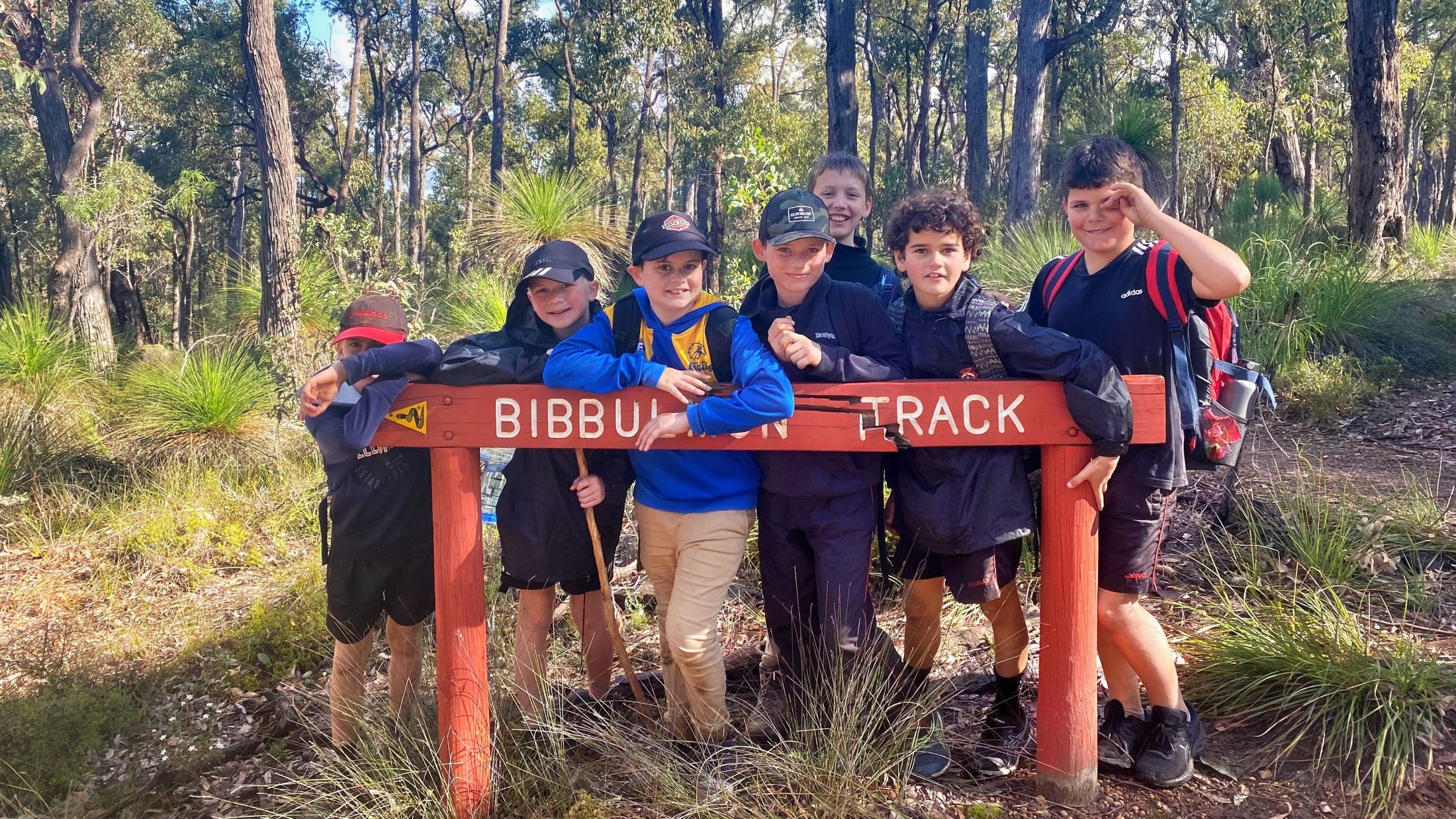 young boys over a bibbulmun track marker sign