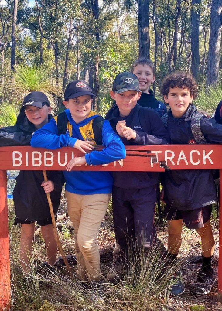 young boys over a bibbulmun track marker sign